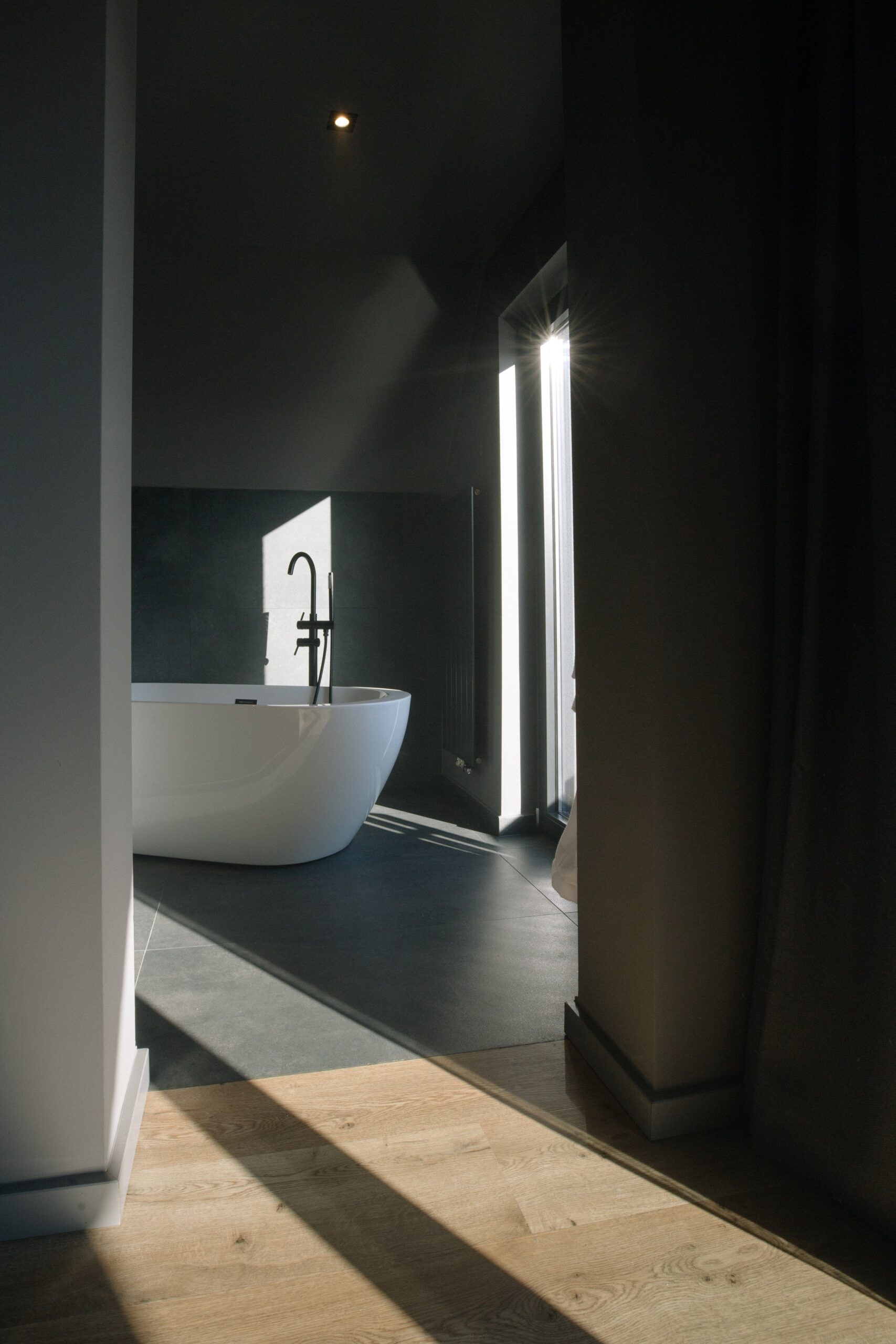 Freistehende Badewanne im dunklen Bad des Le Chalet Noir in Hinterzarten