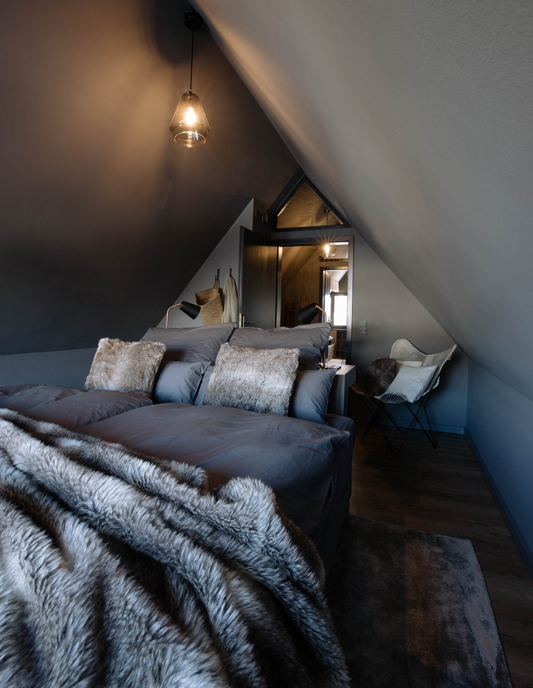 Schlafzimmer unter dem Dach mit Felldecke im Le Chalet Noir in Hinterzarten