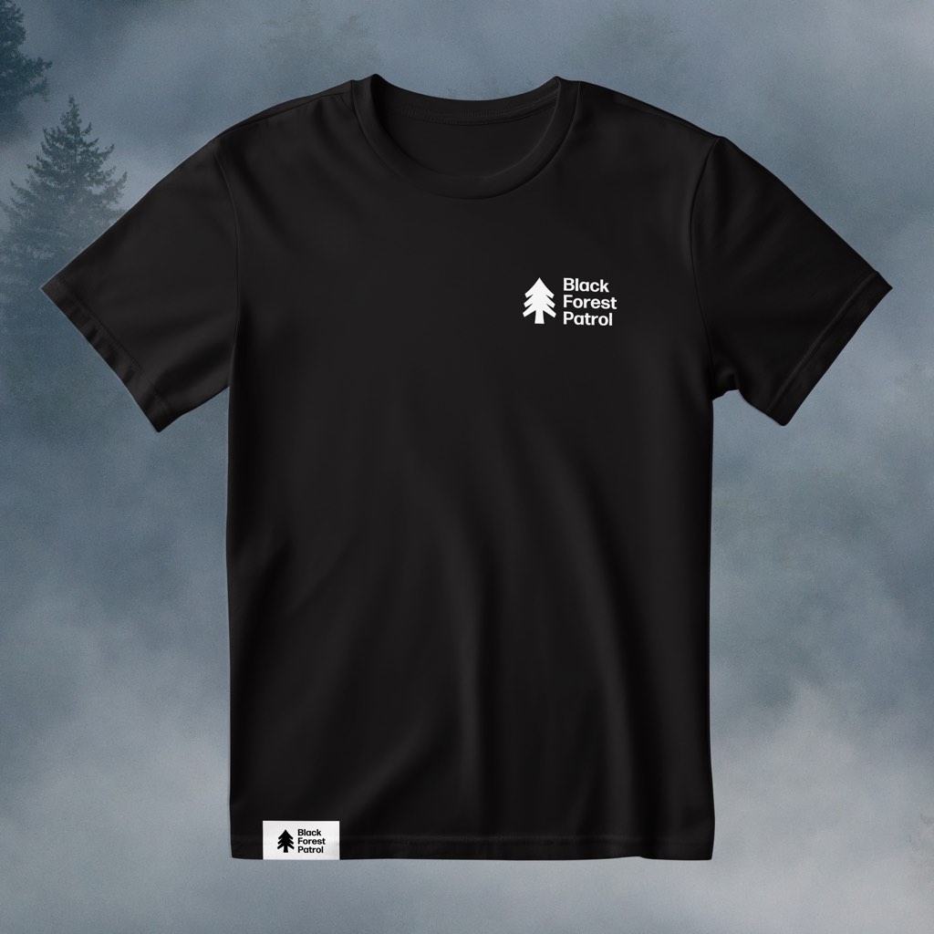 Schwarzes T-Shirt mit kleiner weißer Tanne und Schriftzug auf der Brust