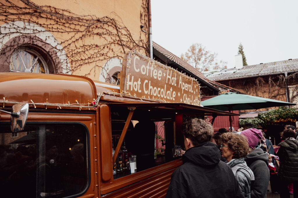 Oranger Oldtimer-Foodtruck mit Heißgetränken im Hof der Fürstenberg Weihnachtswelt