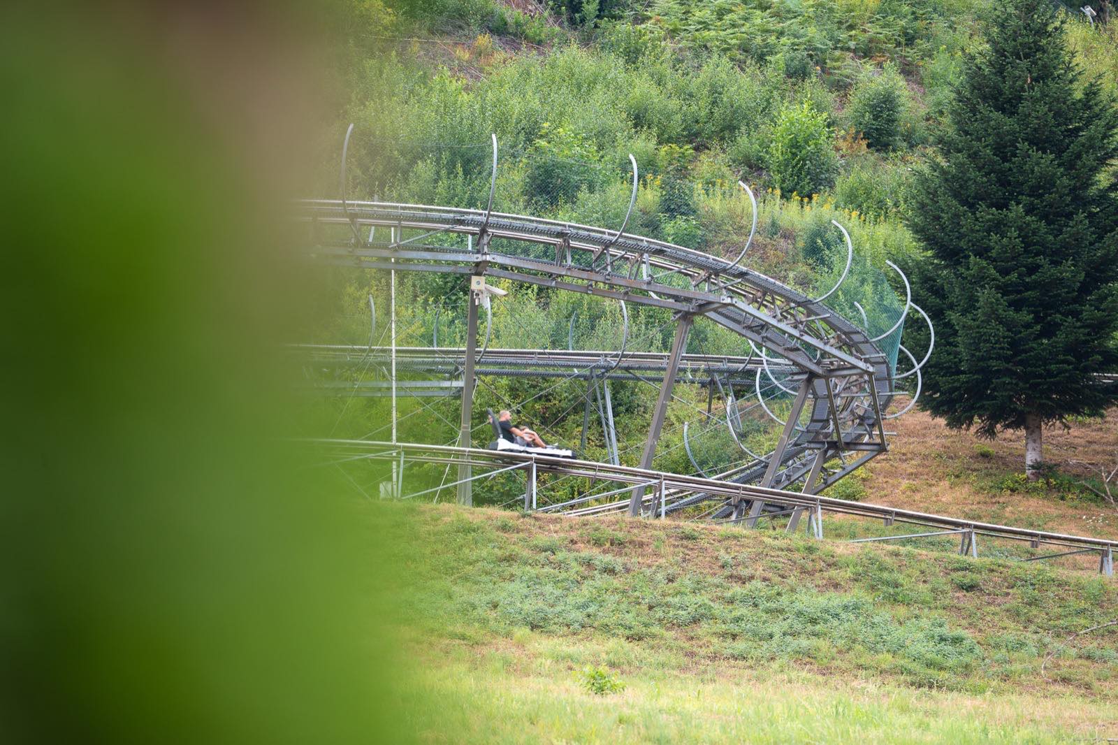 Rodelschlitten mit zwei Personen in einer Steilkurve der Sommerrodelbahn Gutach
